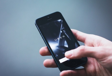 Uber amplía su servicio a Europa en caminones Persona sosteniendo un celular con un mano