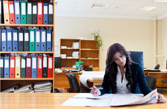 Un foro para la mujer en el mundo empresarial Mujer en un escritorio leyendo un periodico