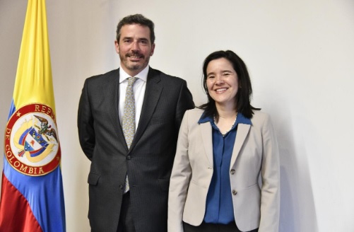 RTVC tiene nuevo gerente Dos personas en una foto detras de una badera