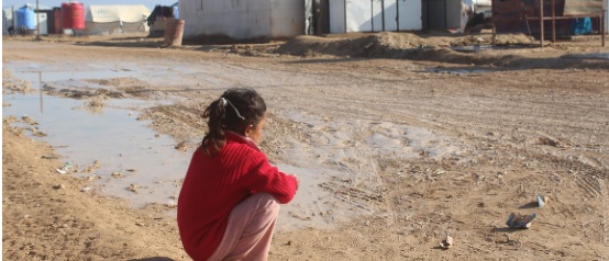 Ayudas humanitarias en Siria Niña sentada mirando una casa
