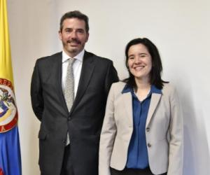 RTVC tiene nuevo gerente Dos personas en una foto detras de una badera