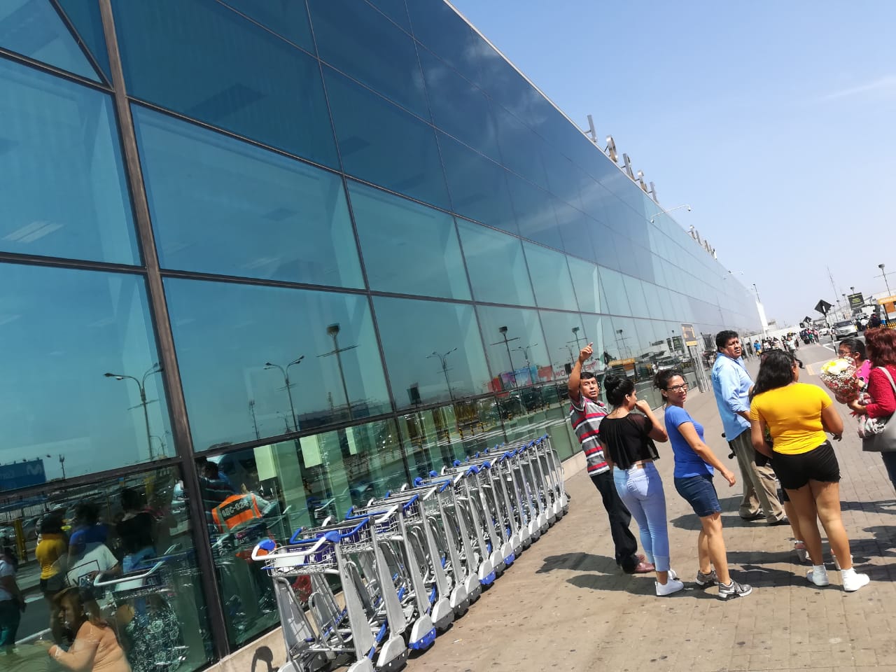 Personas caminando por las afueras del Aeropuerto de Lima
