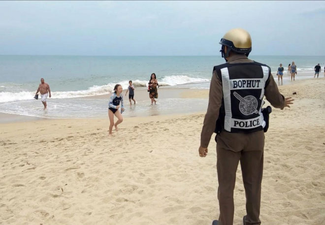 Policia en una paya orientando a turistas