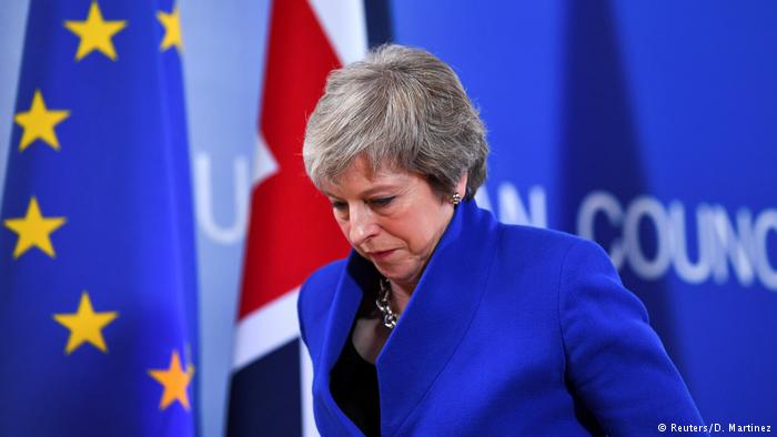 Theresa May caminando con la cabeza abajo