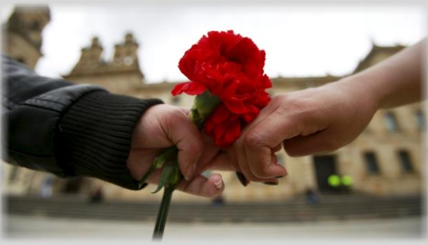 Víctimas del Conflicto Armado Flor en manos de dos personas