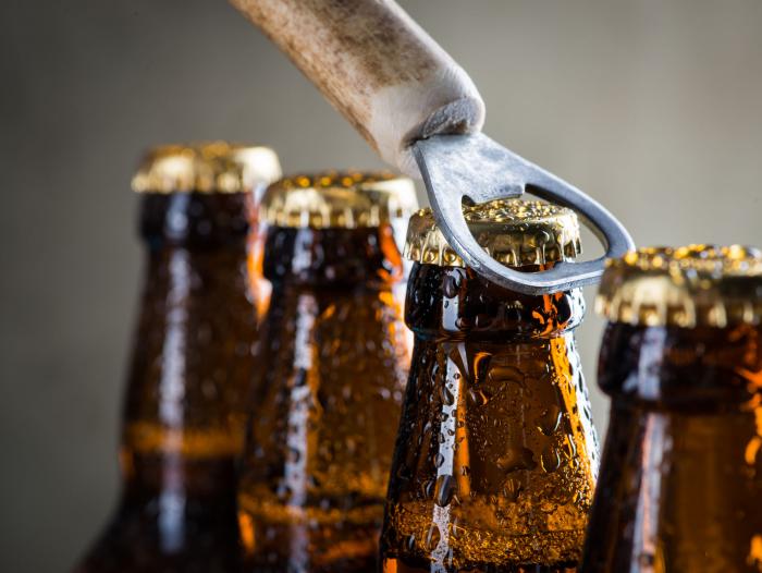 Cuatro cervezas en fila listas para ser destapadas