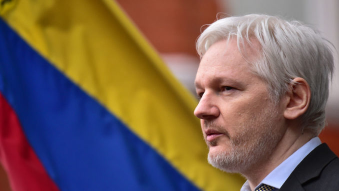 Ecuador no puede garantizar a Julian Assange que no lo extraditara Julian Assange al lado de una bandera de Ecuador