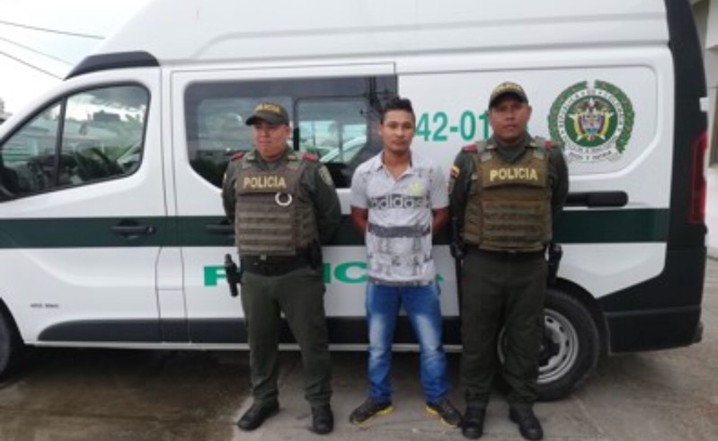Esta persona era buscada por las autorides de Brasil Persona capturada a al lado de dos personas