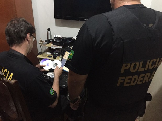 Crime de pornografia infanto-juvenil via web Policia em um escritrio revisando informacoes sobre registros