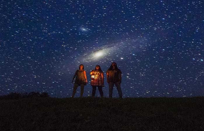 Personas en viendo al cielo una lluvia de meteoros