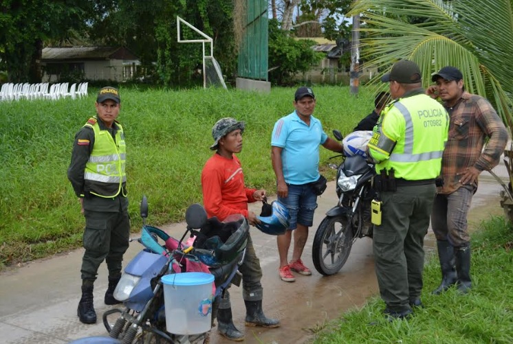 Personas en una calle de Leticia con unos policias