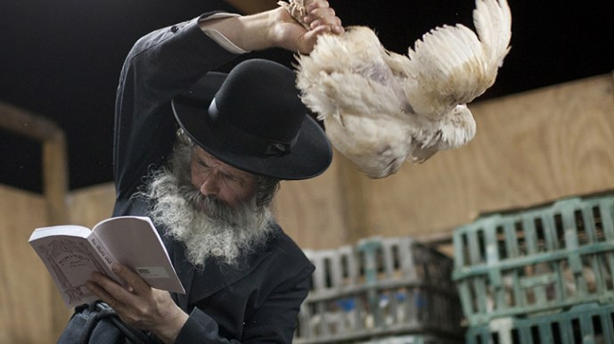 Persona con sombrero con una gallina en la mano en un ritual