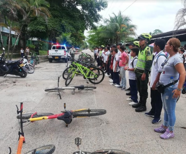 Pedaleando por un ambiente sano Personas en una calle acompañando campaña de la policia