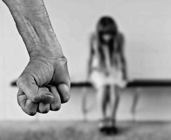 No al maltrato a la mujer Hombre empunñando el puño y de fondo una mujer maltratada