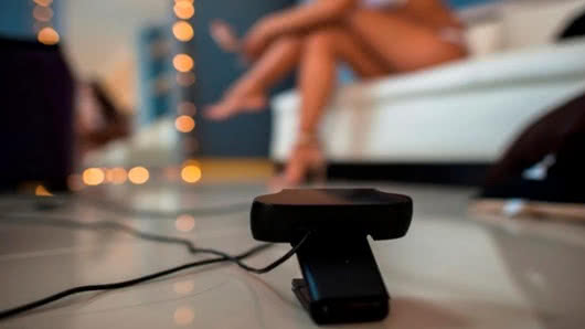 Mujer sentada en un silla y la lado una camara