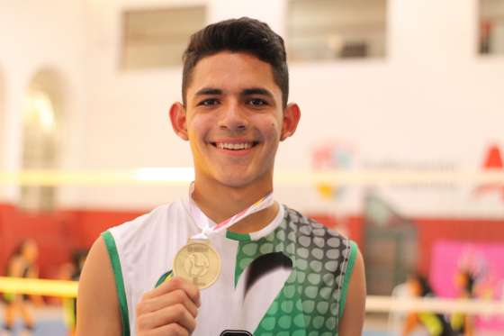 Alejandro Flores sosteniendo una medalla de oro