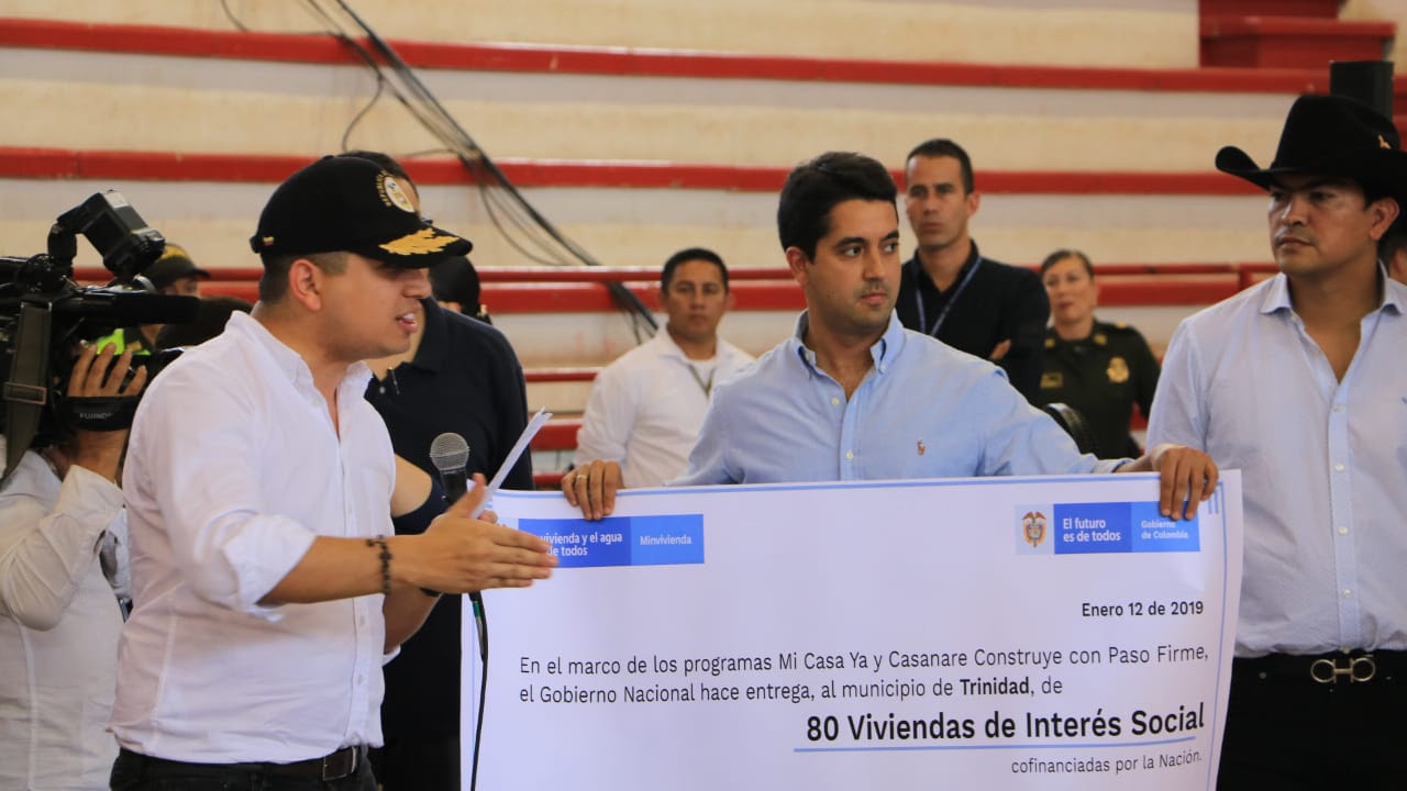 Personas sosteniendo un cheque simulado en tamaño grande