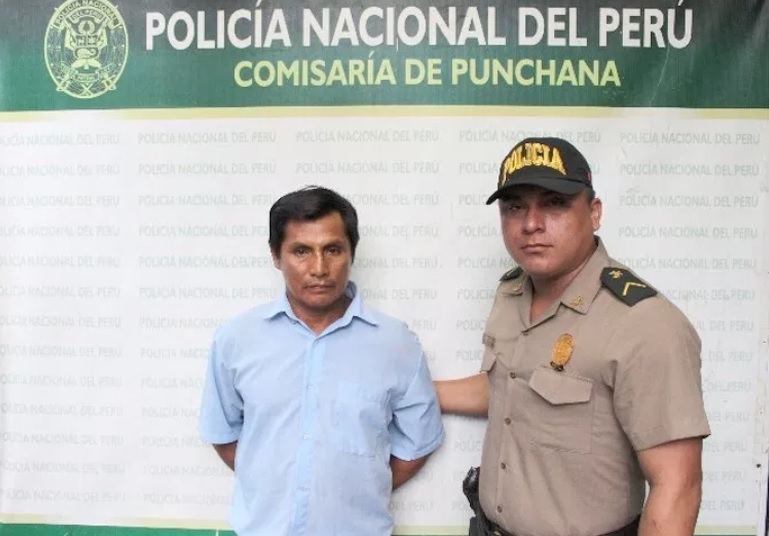 Policial al lado de un capturado