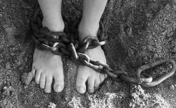 Persona con pies amarrados con unas cadenas