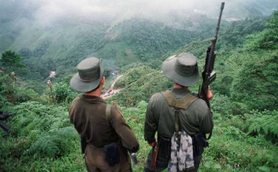 Personas armadas en mirando en un alto de montaña