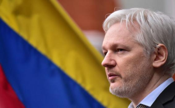 Julian Assange al lado de una bandera de Ecuador