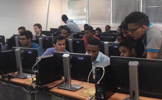 Estudiante se prestaran en ciberseguridad Jovenes en un salon viendo algo en una pantalla de computador