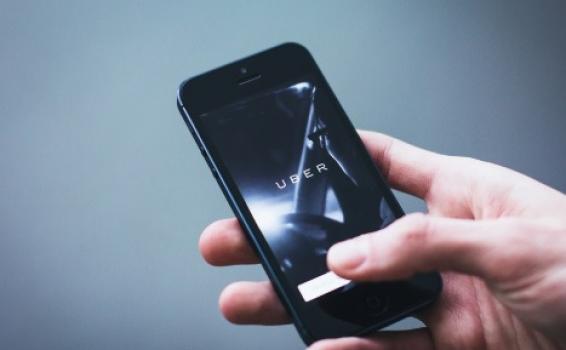 Uber amplía su servicio a Europa en caminones Persona sosteniendo un celular con un mano