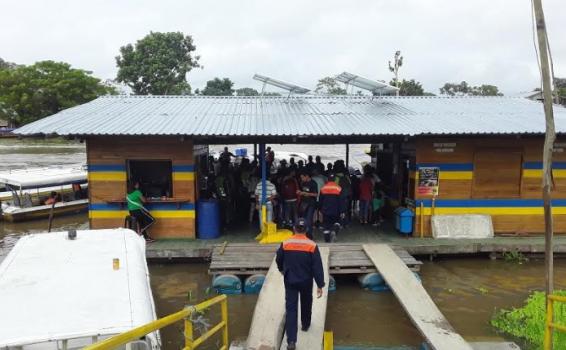 Personas en una casa sobre el agua en el puerto de Leticia