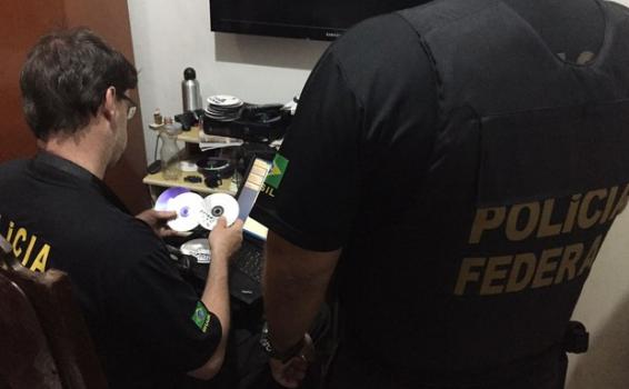 Crime de pornografia infanto-juvenil via web Policia em um escritrio revisando informacoes sobre registros