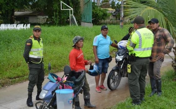 Personas en una calle de Leticia con unos policias