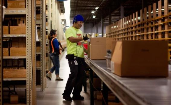 Persona en una fabrica de medicamentos empacando en caja