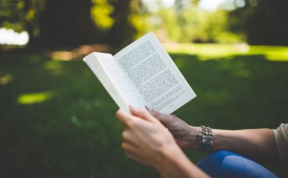 Persona sosteniendo y leyendo un libro