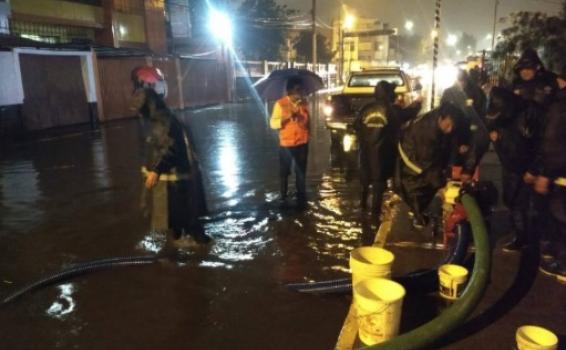 El Senamhi alerto que las lluvias intensas continuaran presentandose Personal de bomberos drenando alcantarilla