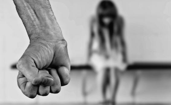 No al maltrato a la mujer Hombre empunñando el puño y de fondo una mujer maltratada