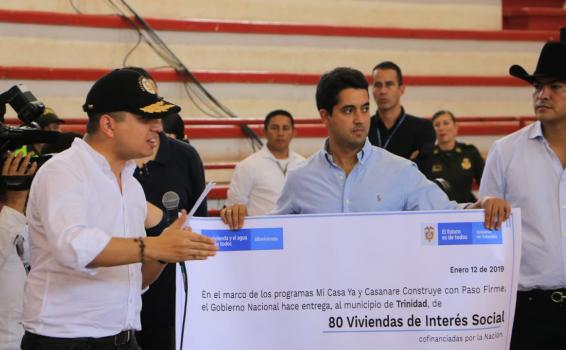 Personas sosteniendo un cheque simulado en tamaño grande