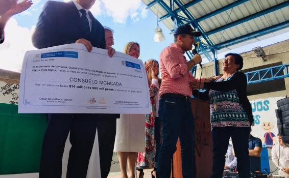 Personas en entrega de cheque de vivienda