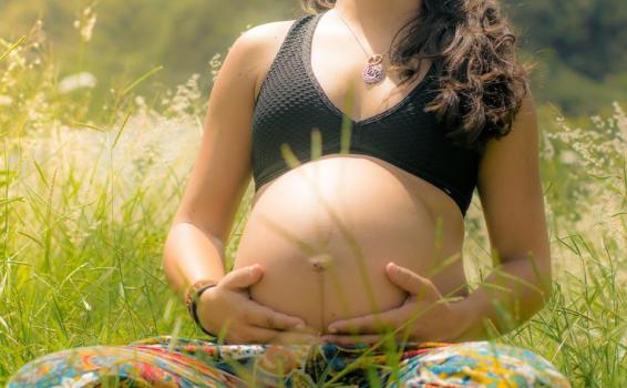 Mujer embarazada sentada en un campo