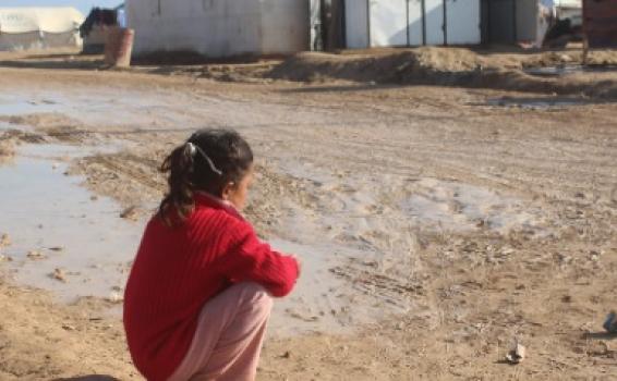 Niña sentada mirando una casa