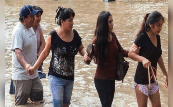 Piuranos afectados por el Niño Costero aún se sienten en emergencia Personas pasando al lado de un rio formado por lluvias