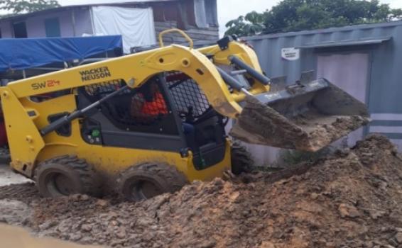 Relleno de la calle en mal estado Tractor removiendo tierra en una calle de Iquitos