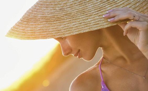 Mujer con un sombrero cubriendose del sol