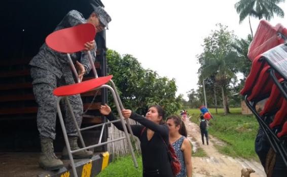 Personas subiendo sillas a un camion