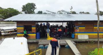 Personas en una casa sobre el agua en el puerto de Leticia