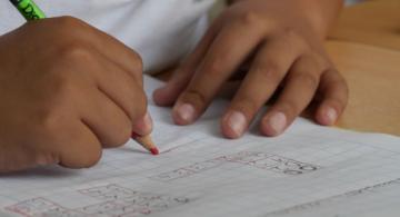 Niño escribiendo en una mesa