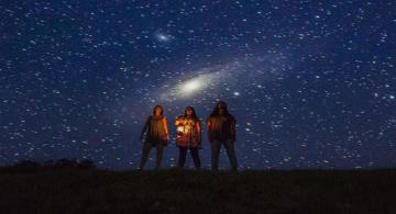 Personas en viendo al cielo una lluvia de meteoros