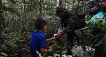 Militares entregando comida a niño en la selva 