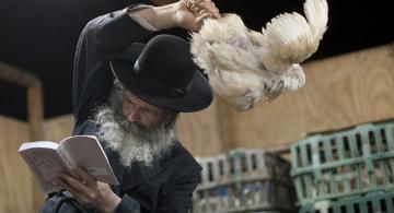 Persona con sombrero con una gallina en la mano en un ritual