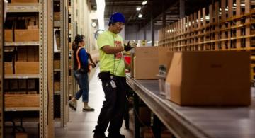 Persona en una fabrica de medicamentos empacando en caja