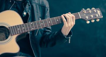 Persona tocando melodia en una guitarra