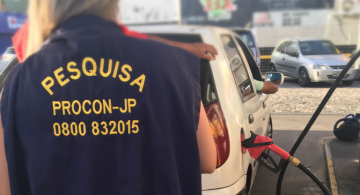 Mulher ao lado de um posto de gasolina